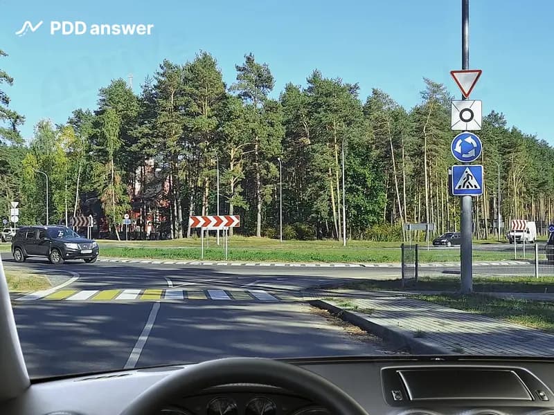 Что означают дорожные знаки, установленные перед перекрёстком, на котором организовано круговое движение, в показанной ситуации?