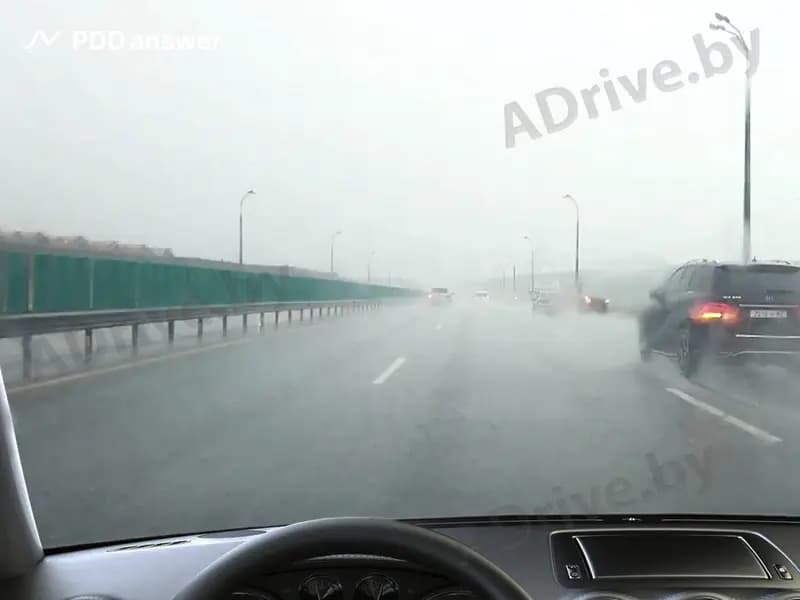 Как водитель должен поступить в случае потери сцепления передних колёс с поверхностью дороги во время сильного дождя?
