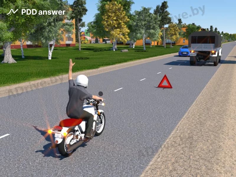 О чём предупреждает водитель мотоцикла, подавая такой жест левой рукой?