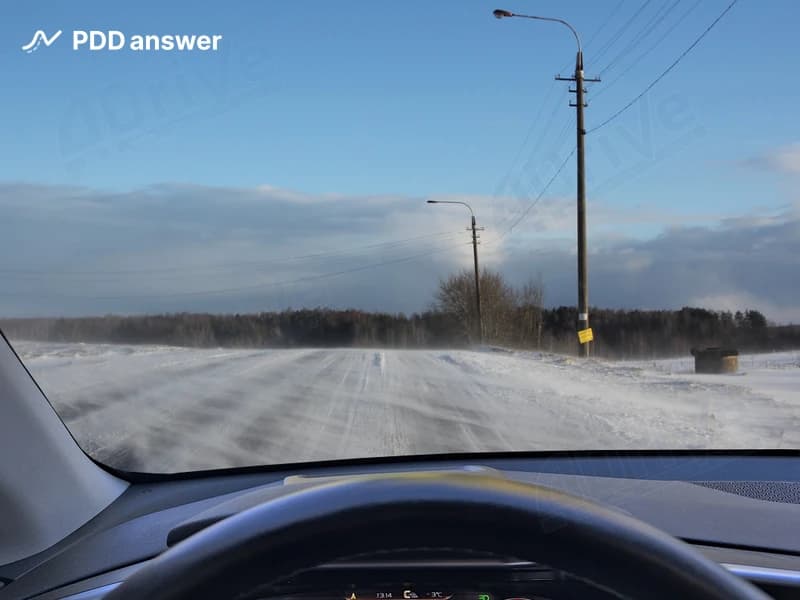 Вы выехали на вершину холма и почувствовали, как автомобиль дёргает резкими порывами бокового ветра. Как следует поступить в такой ситуации?