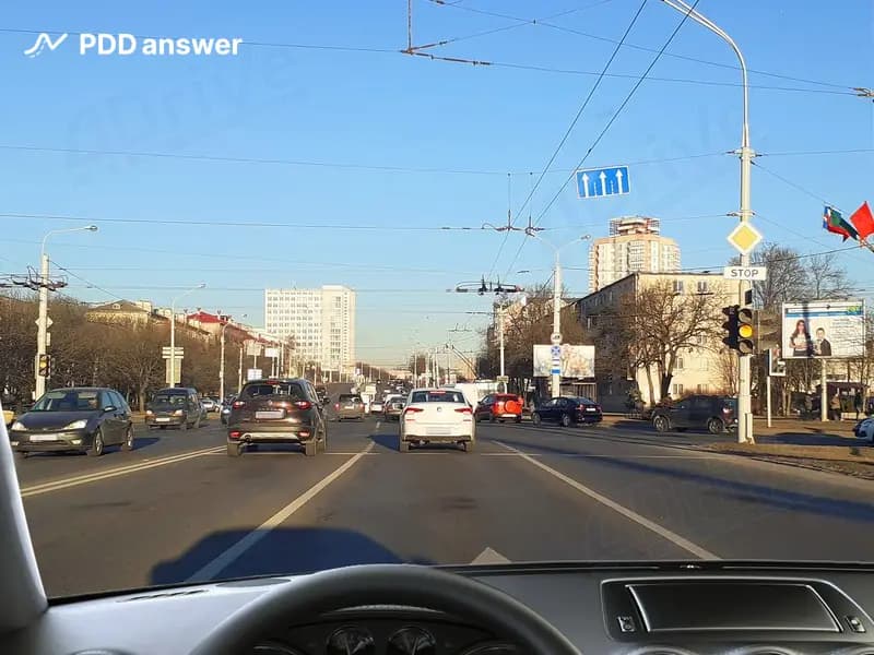 Как Вам, двигаясь в транспортном потоке со скоростью около 40 км/ч, следует поступить в показанной ситуации при включении жёлтого сигнала светофора?