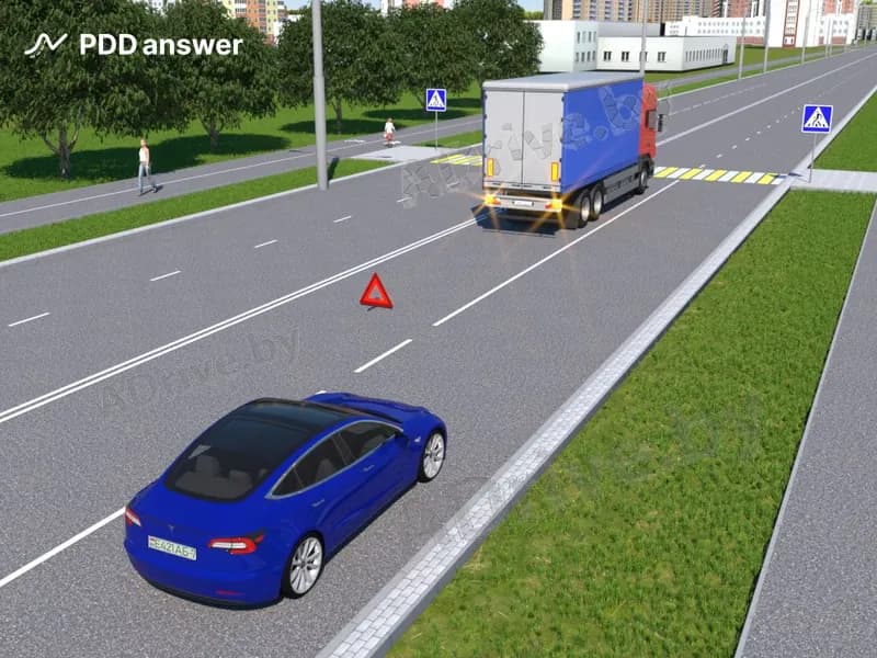 Как должен поступить водитель синего легкового автомобиля, если на соседней полосе стоит грузовой автомобиль, совершивший вынужденную остановку?