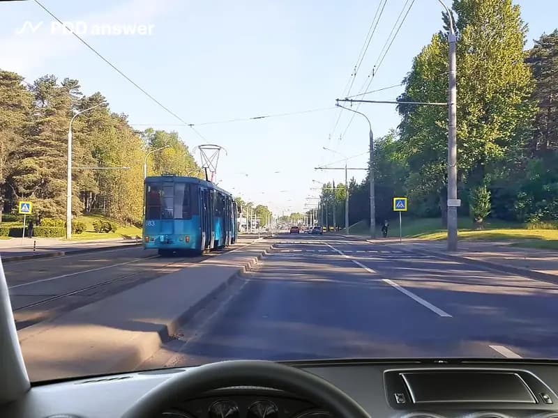 Как Вам следует поступить в показанной ситуации, приближаясь к трамваю, стоящему с включённой аварийной световой сигнализацией на остановочном пункте и осуществляющему посадку (высадку) пассажиров?