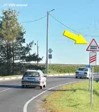 О чём предупреждает водителей показанный стрелкой дорожный знак?