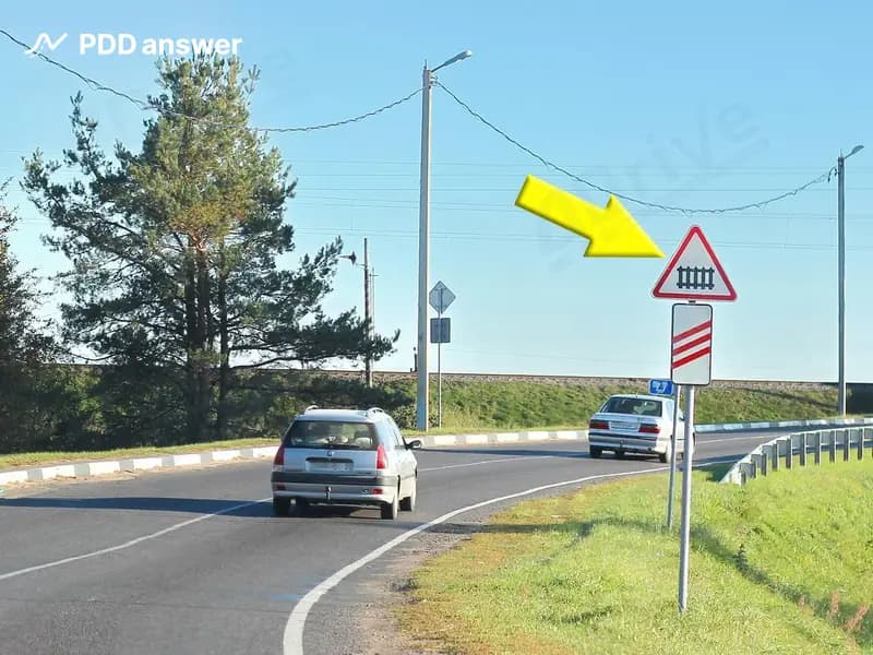 О чём предупреждает водителей показанный стрелкой дорожный знак?