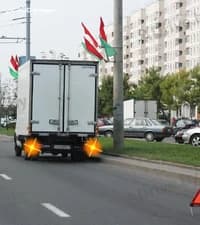 На каком минимальном расстоянии от транспортного средства при вынужденной остановке в населённом пункте должен быть установлен знак аварийной остановки?