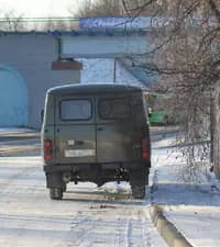 Как можно наилучшим образом обеспечить неподвижность автомобиля с механической трансмиссией при его постановке на стоянку на участке дороги, где имеется продольный уклон?